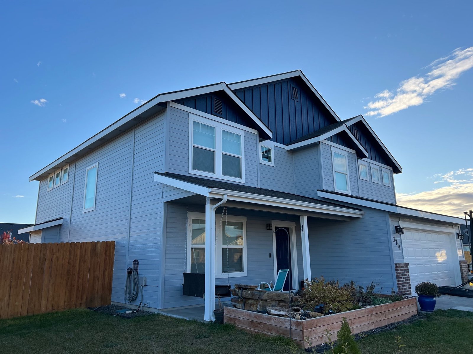 Modern exterior house in Eagle, ID, featuring gray siding, multiple windows, and a black roof, showcasing professional painting quality by Funky Painting.