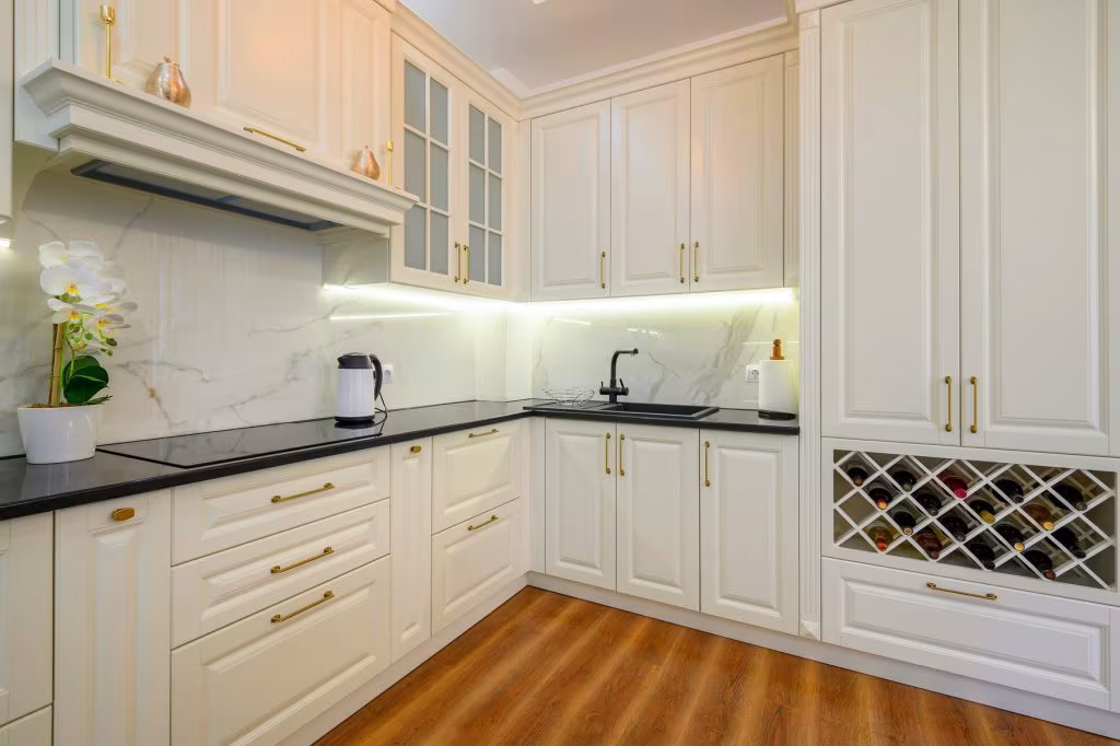 Modern kitchen with white cabinetry, black countertops, and gold hardware, showcasing a sleek design ideal for cabinet refinishing services in Star, Idaho.
