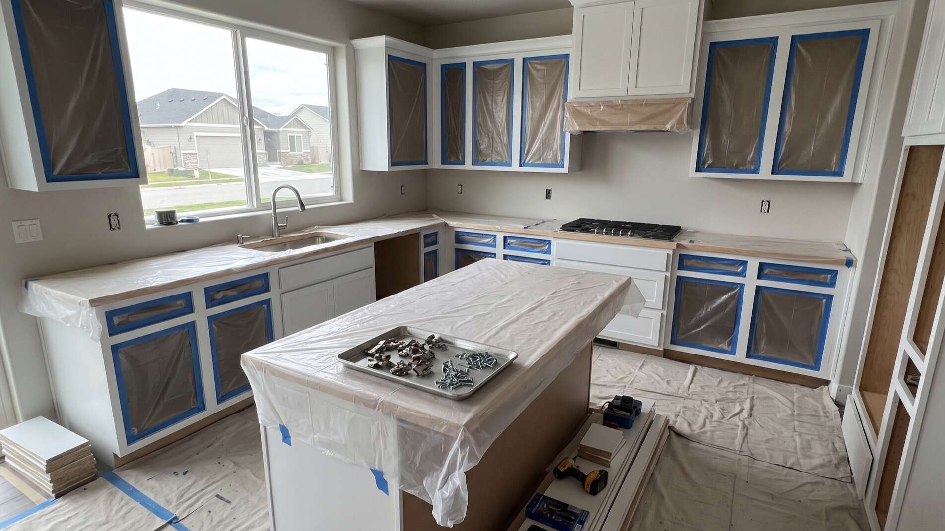 Meridian kitchen mid cabinet refinishing with masked boxes and doors removed for spraying