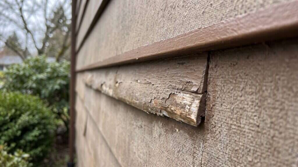 Swollen masonite siding edges on a Garden City, Idaho home before exterior painting