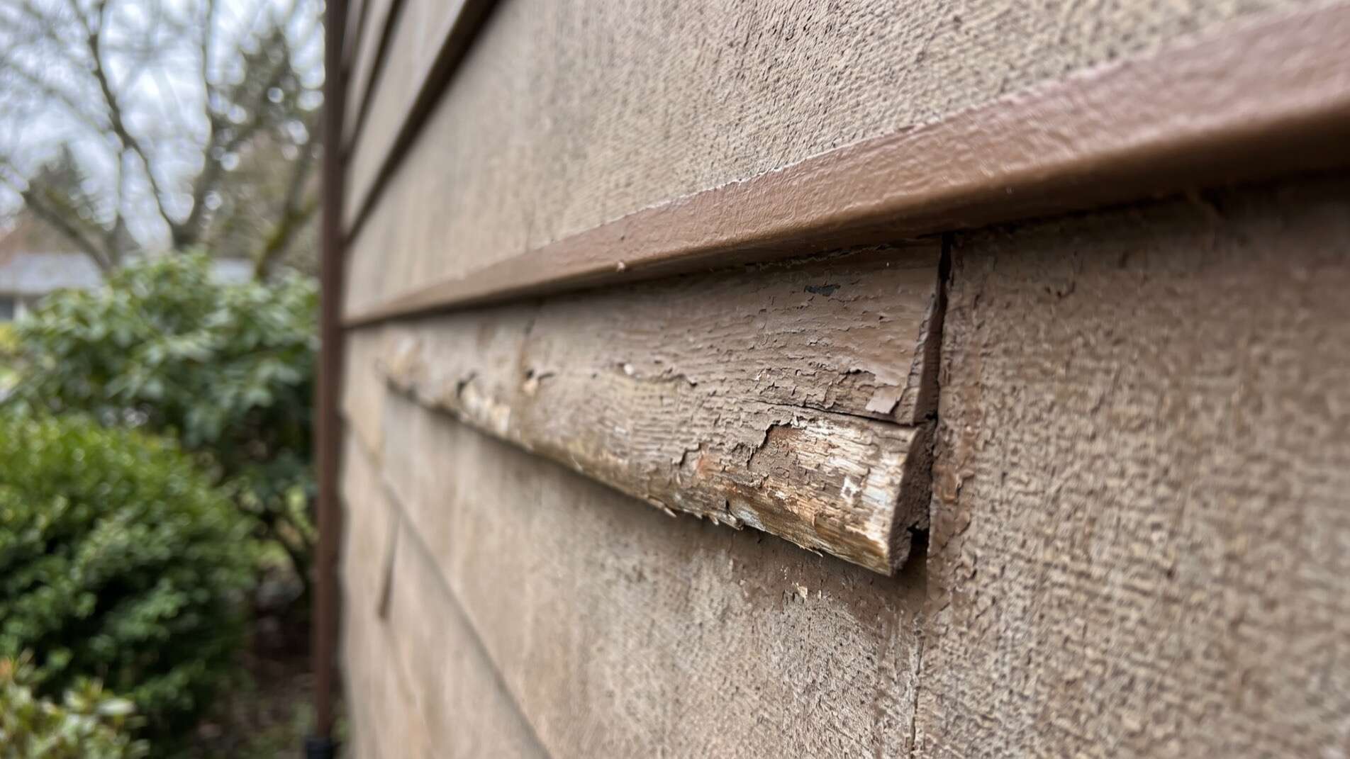 Swollen masonite siding edges on a Garden City, Idaho home before exterior painting